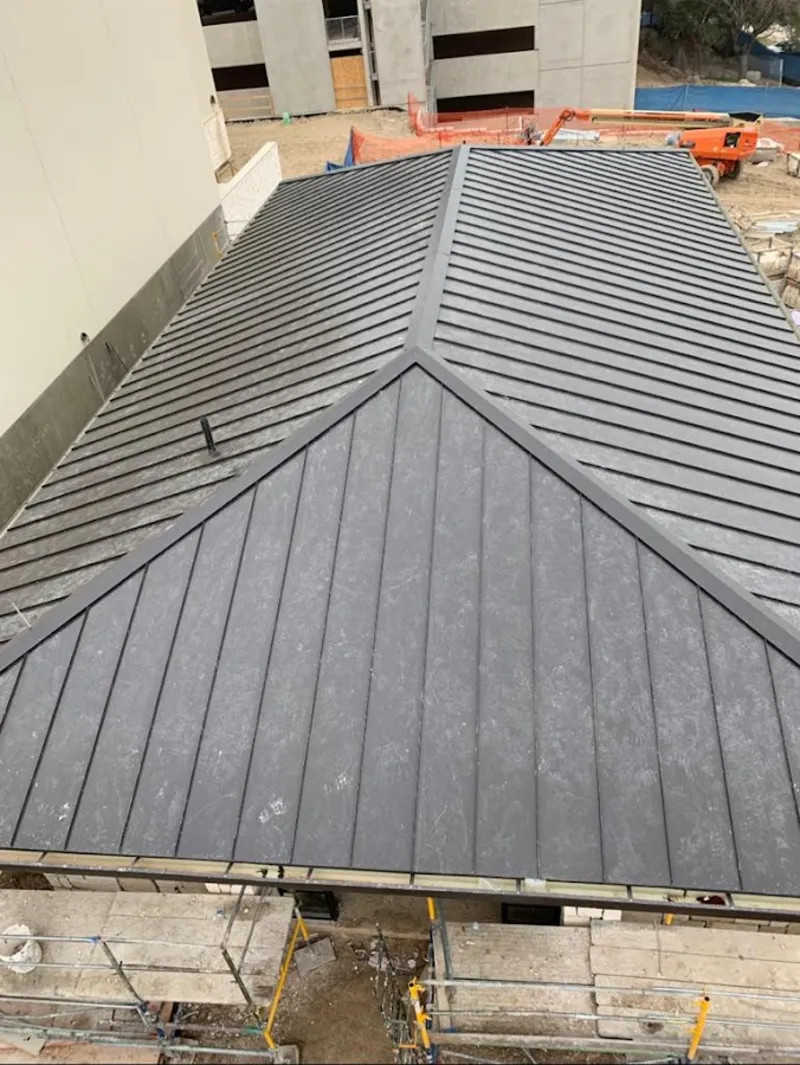 Commercial metal roof construction with crane equipment in Dexter